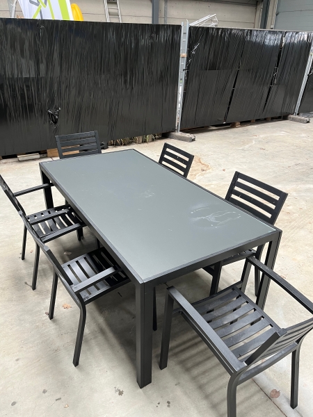 une table de jardin rectangulaire noire (184 cm x 94cm ; 74 cm de hauteur) et 6 chaises assorties