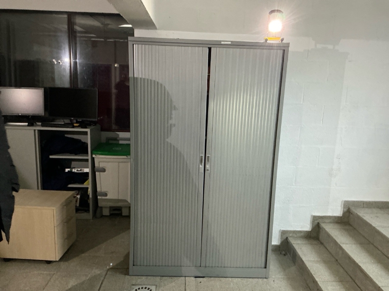 Une armoire métallique grise, volets coulissants, 5 niveaux, dimensions : 120 cm de largeur x 195 cm de hauteur x 40 cm de profondeur 