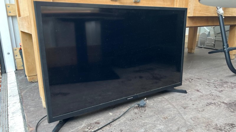 Une télévision écran plat  SAMSUNG (sans télécommande correspondante)
Un meuble TV stratifié noir 2 portes 